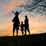Silhouette of two adults and two children at sunset