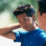 teen boy looking unsure, holding the back of his neck.