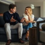 a male and femle couple sitting ona a couch talking