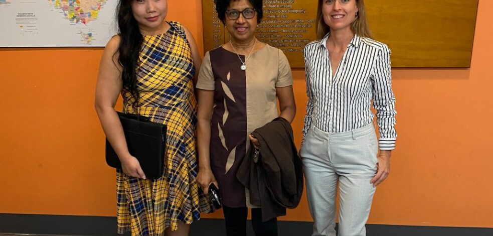 Three practitioners stand together and smile for a photo.