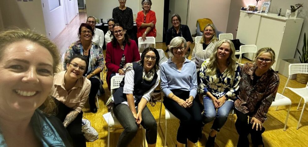 A group of practitioners gather for a photo after a meeting presentation.