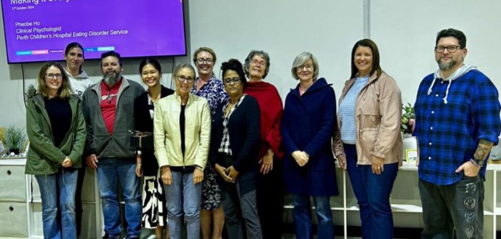 A group of practitioners stand together for a photo after their meeting.